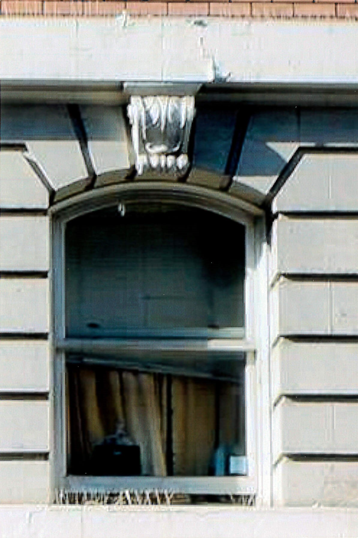 Close up view of window in the rusticated second floor facade